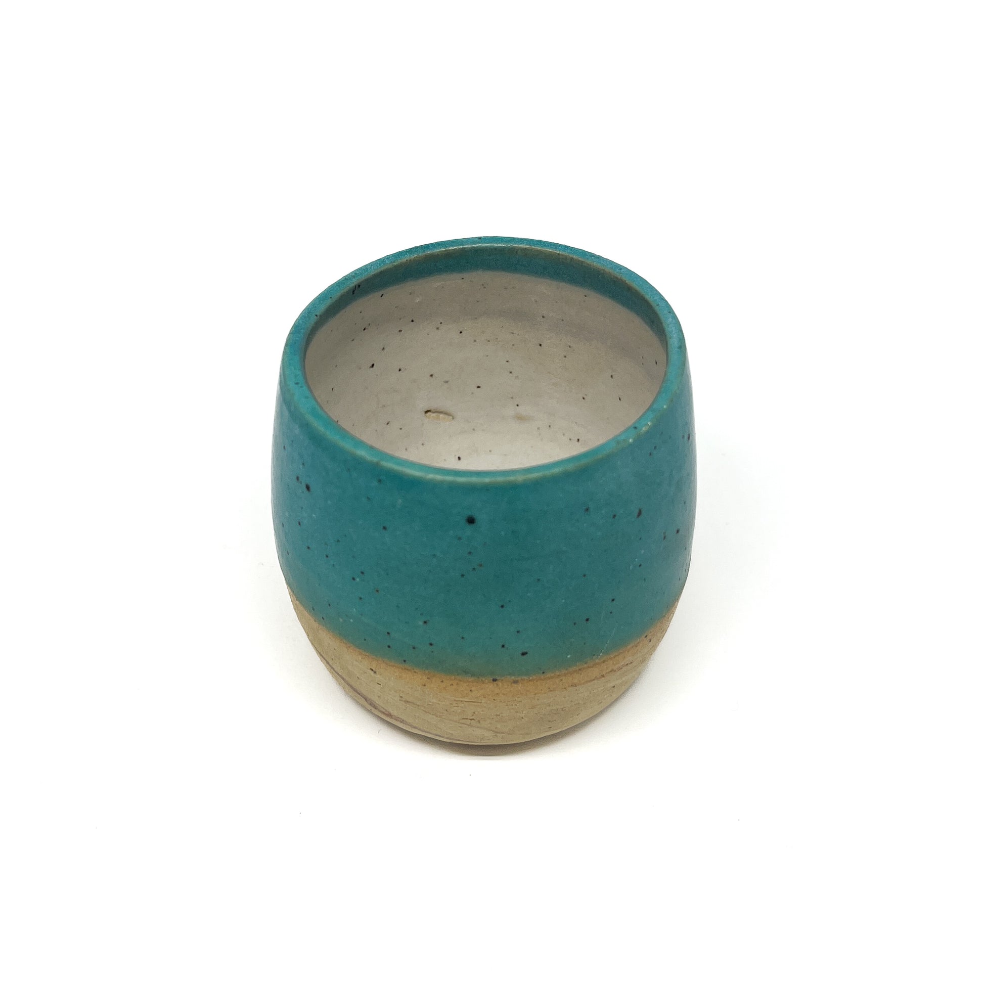 Speckled ceramic cup with a teal exterior glaze and a natural, unglazed bottom and interior.