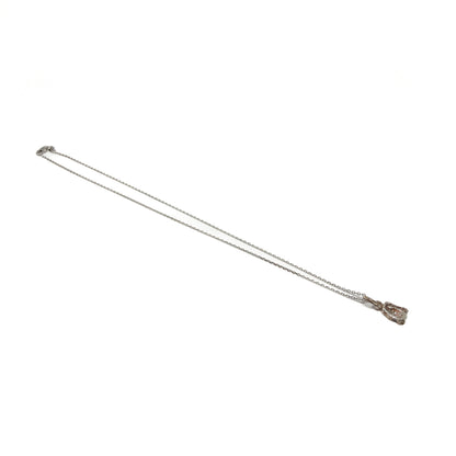Small silver pendant necklace, lying diagonally.