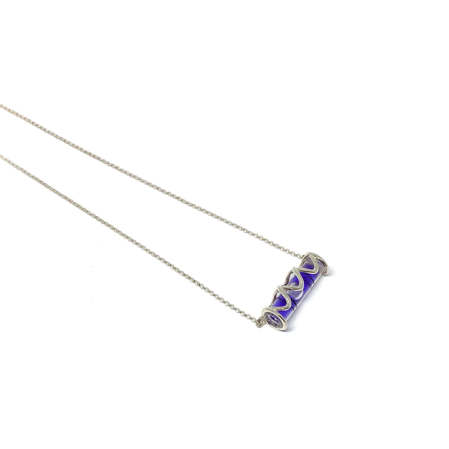 Silver necklace with a cylindrical glass pendant containing swirling vibrant purple pigment.