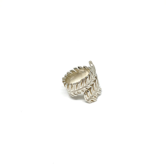 Silver ring shaped like a stylized fern leaf, wrapping around the finger.