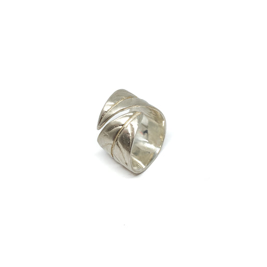 Silver ring with a textured, overlapping leaf design that wraps around the finger.