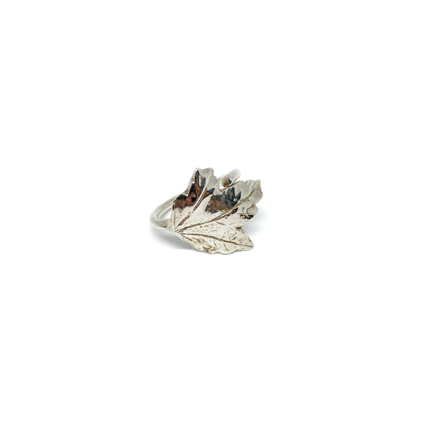 A shiny silver ring shaped like a detailed maple leaf.