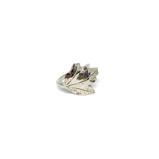 A shiny silver ring shaped like a detailed maple leaf.