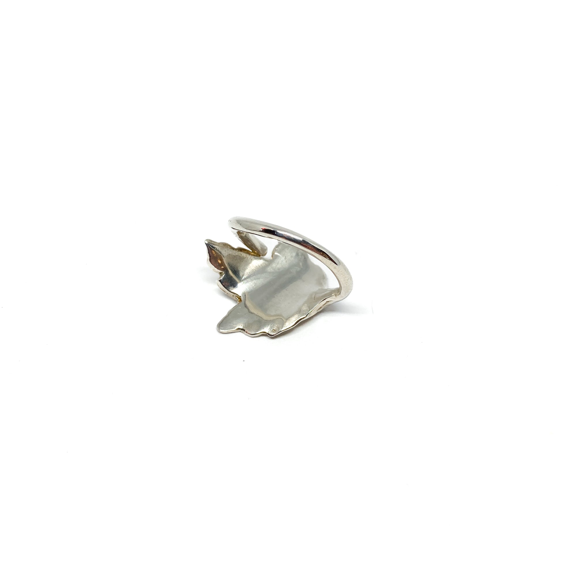 A shiny silver ring with a detailed maple leaf design is shown at an angle.