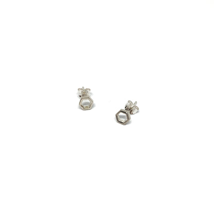 Two shiny silver stud earrings, each shaped like a small, open hexagon, are displayed.