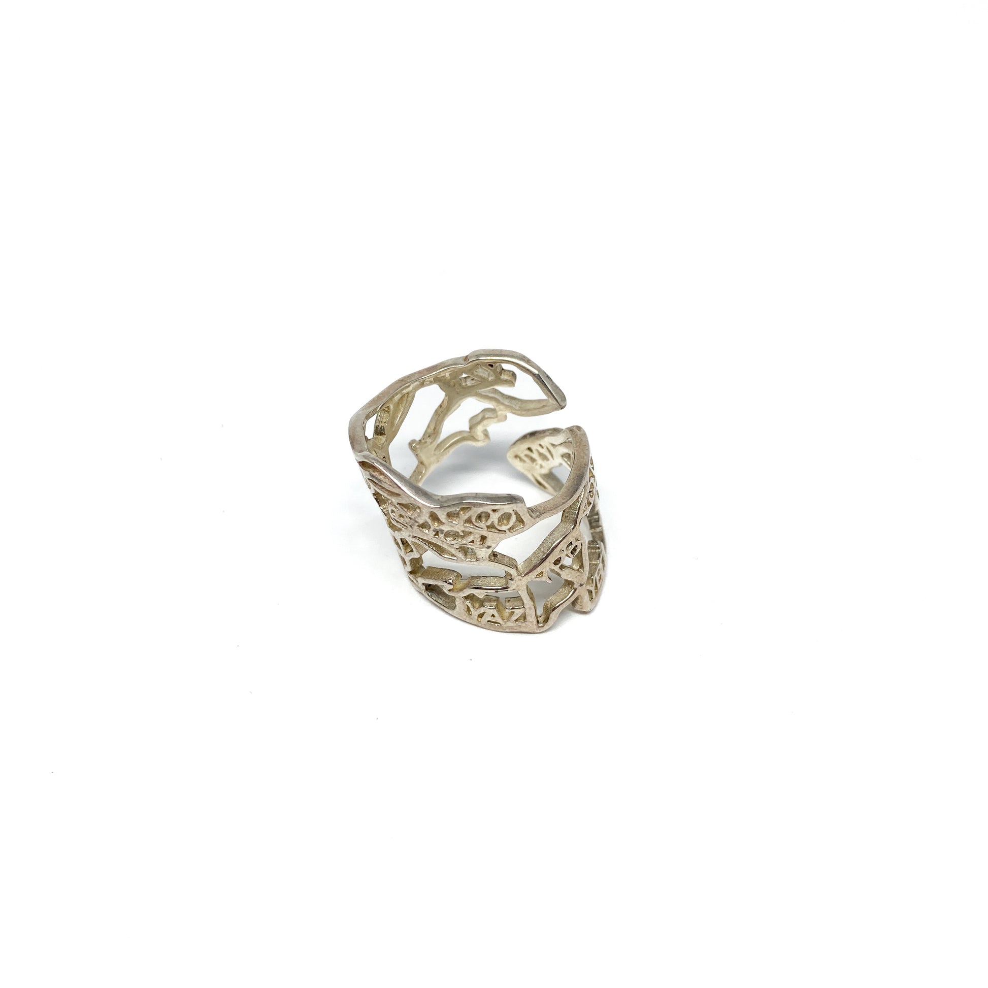 A shiny silver ring with an intricate cut-out design resembling the map of Canada is displayed.