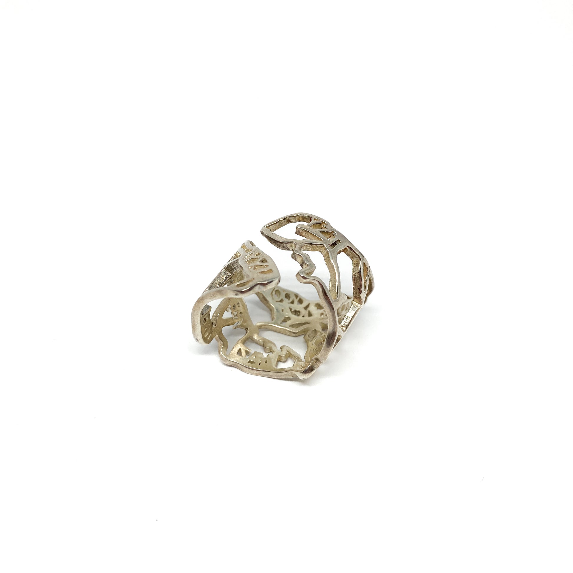 A shiny silver ring with a detailed cut-out design of the map of Canada is shown.