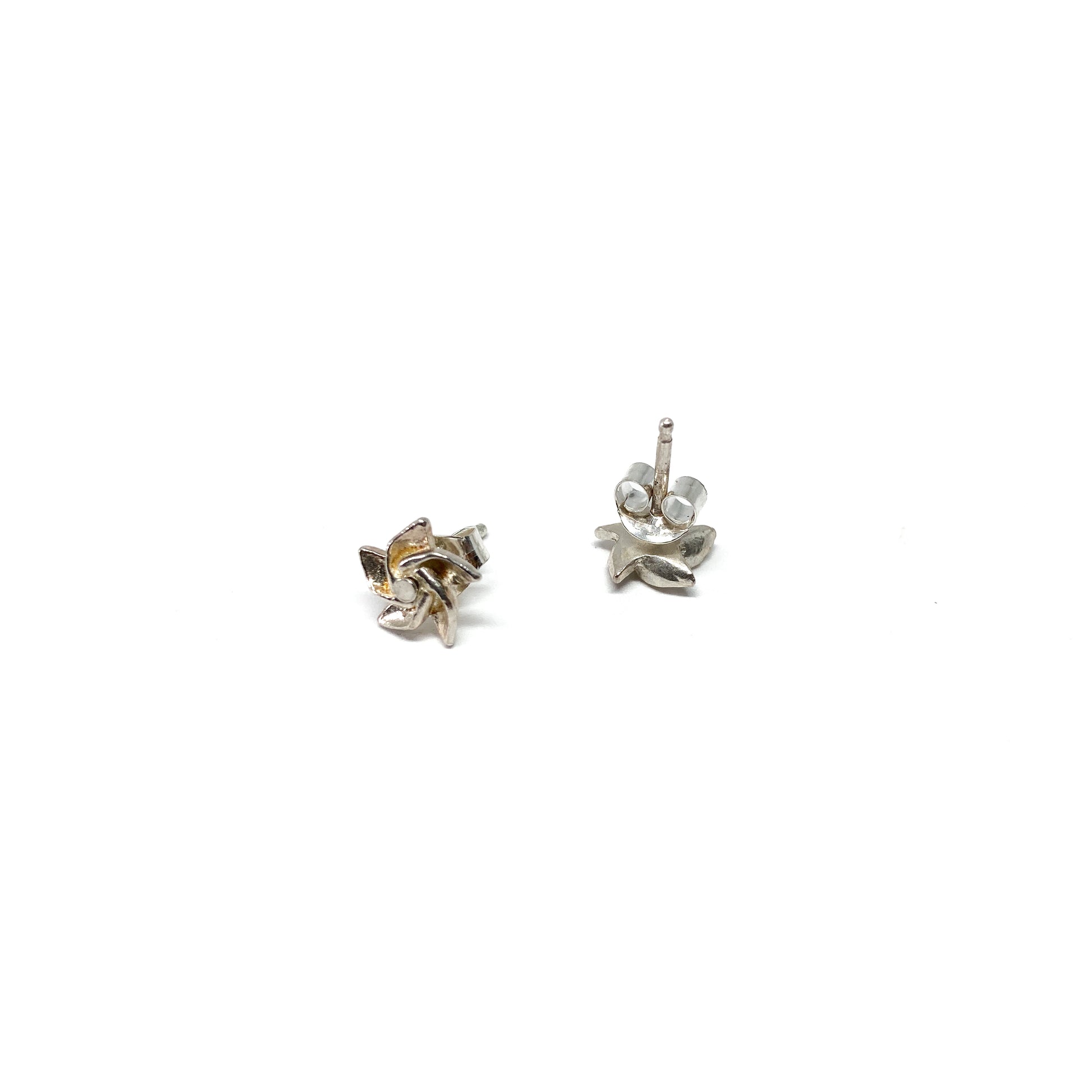Two shiny silver stud earrings with a stylized, three-lobed design are displayed, one showing the post and back.
