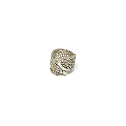 A shiny silver ring shaped like two overlapping dragonfly wings with intricate vein details wraps around.