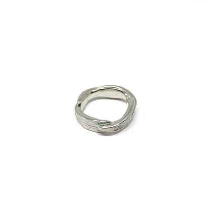 A shiny silver ring with a textured, organic design resembling twisted bamboo is shown.