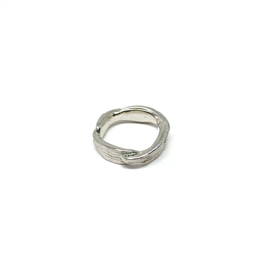 A shiny silver ring with a textured, organic design resembling twisted bamboo is shown.