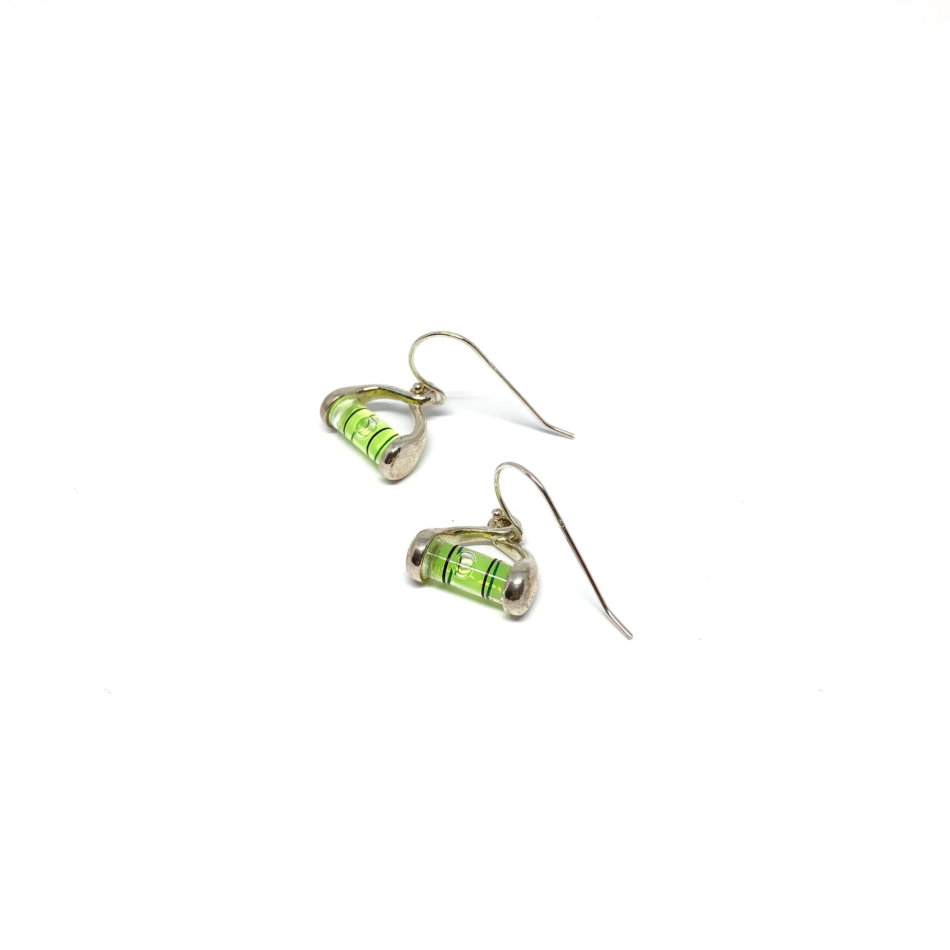 Silver dangle earrings shaped like miniature levels with green liquid and a centered clear bubble.