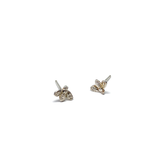 Two shiny silver stud earrings, each shaped like a bee, are shown.