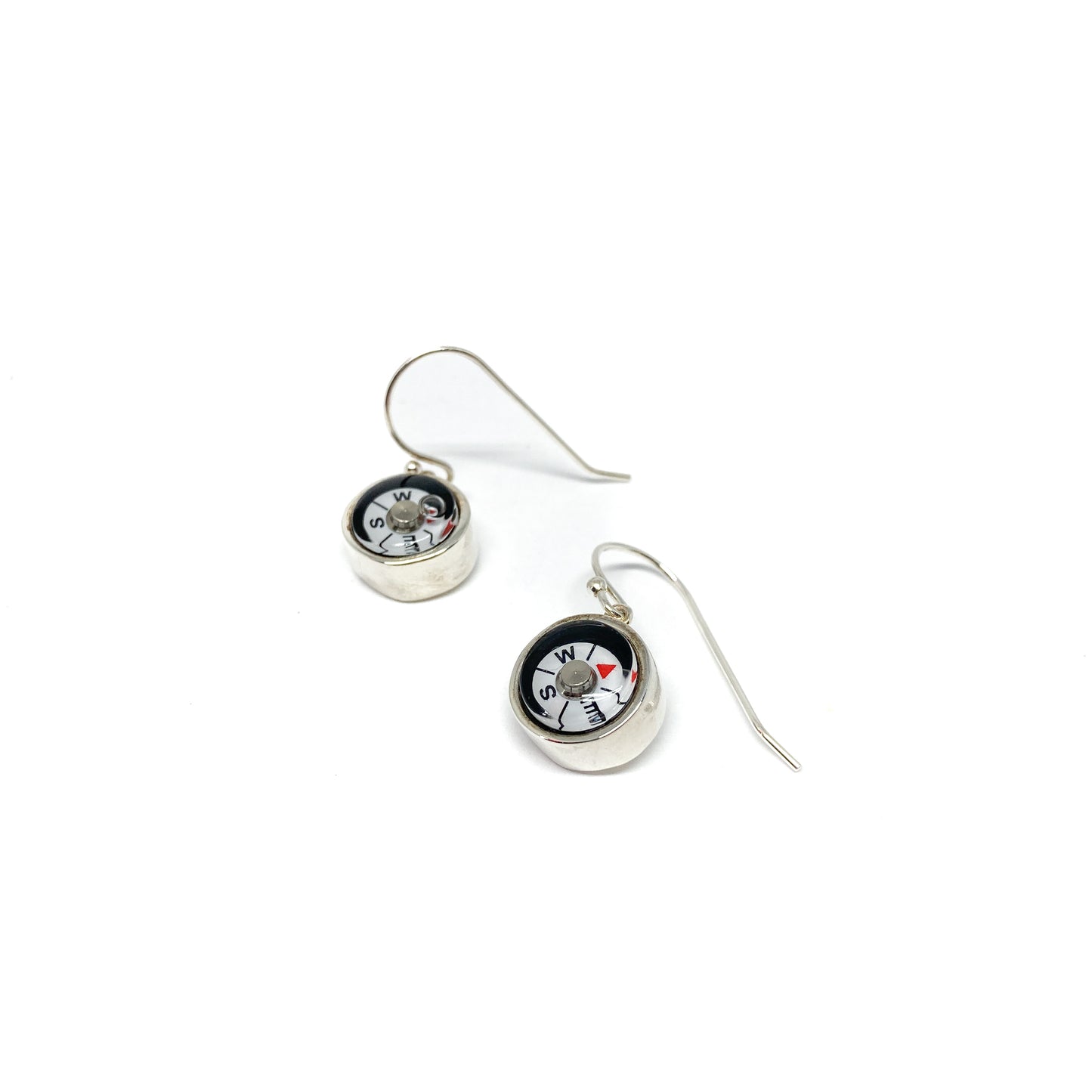 Two shiny silver dangle earrings feature miniature compasses with visible north, south, east, and west markings.