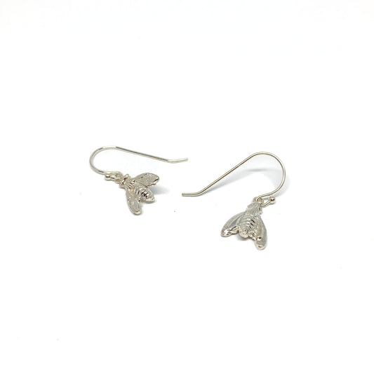 Two shiny silver dangle earrings, each shaped like a detailed bumblebee, hang from fishhook wires.