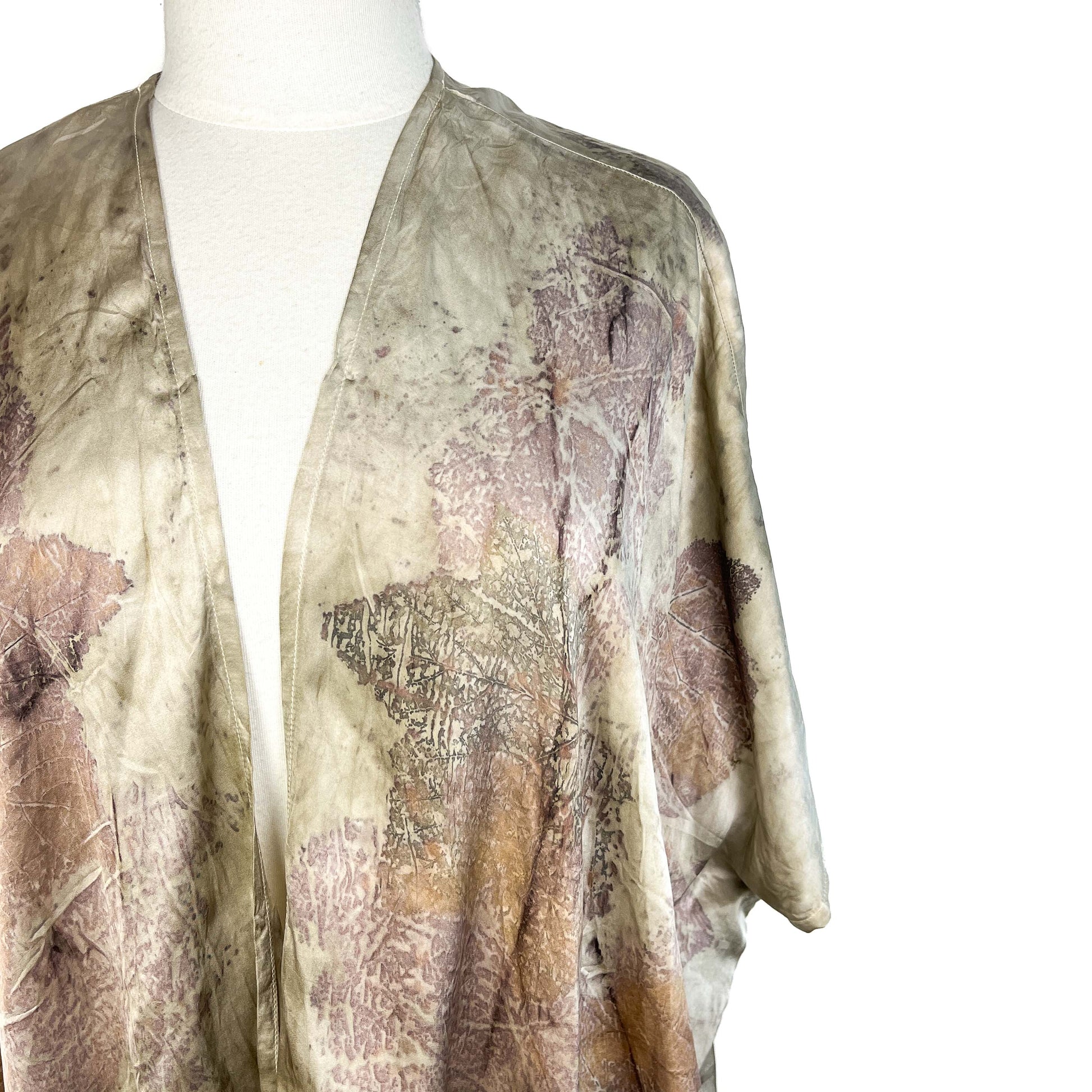 Detail of Short Silk Cardigan showing natural leaf impressions and fluid silk drape at the shoulder.
