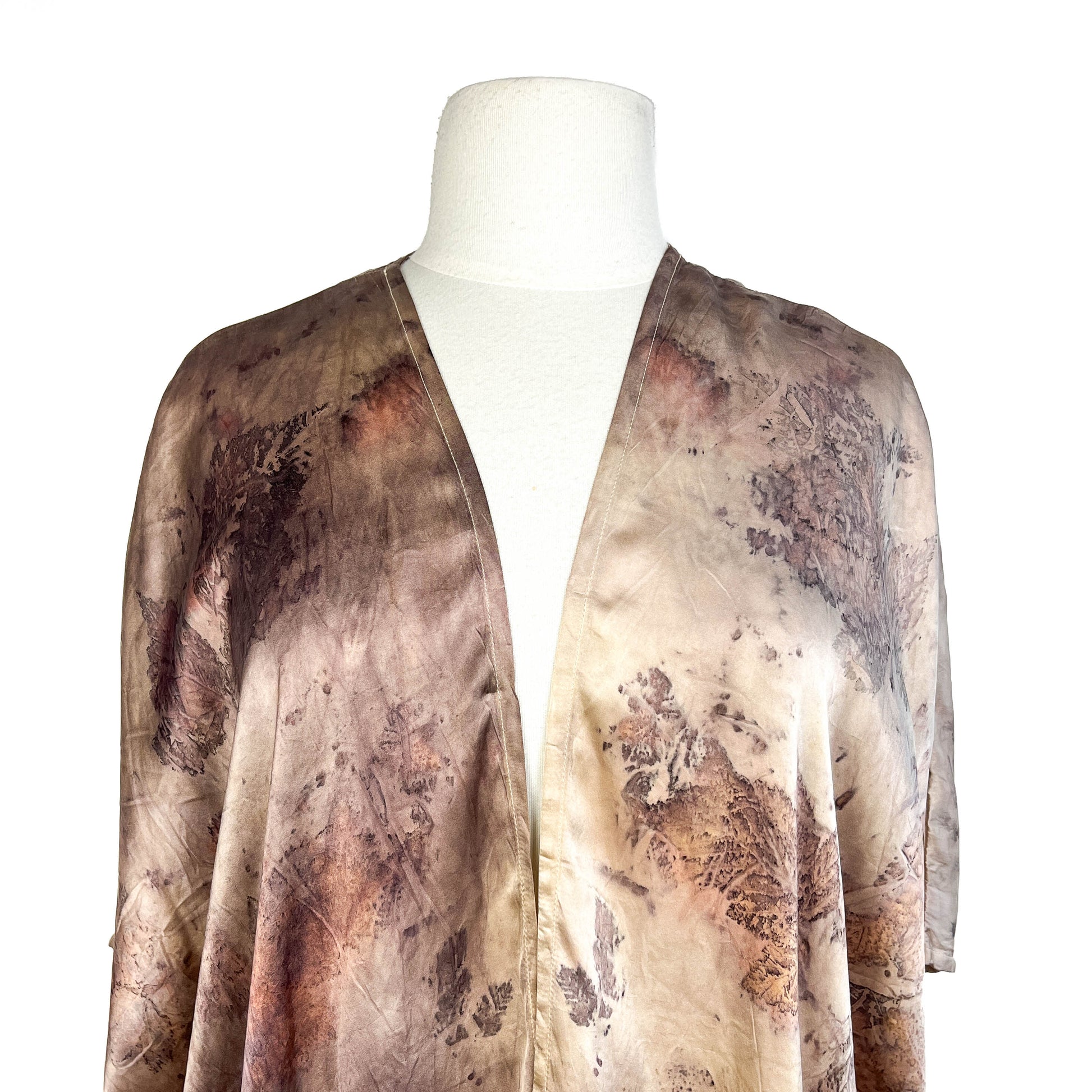 Close-up of Short Silk Cardigan showing delicate leaf patterns and detailed stitching around the neckline.