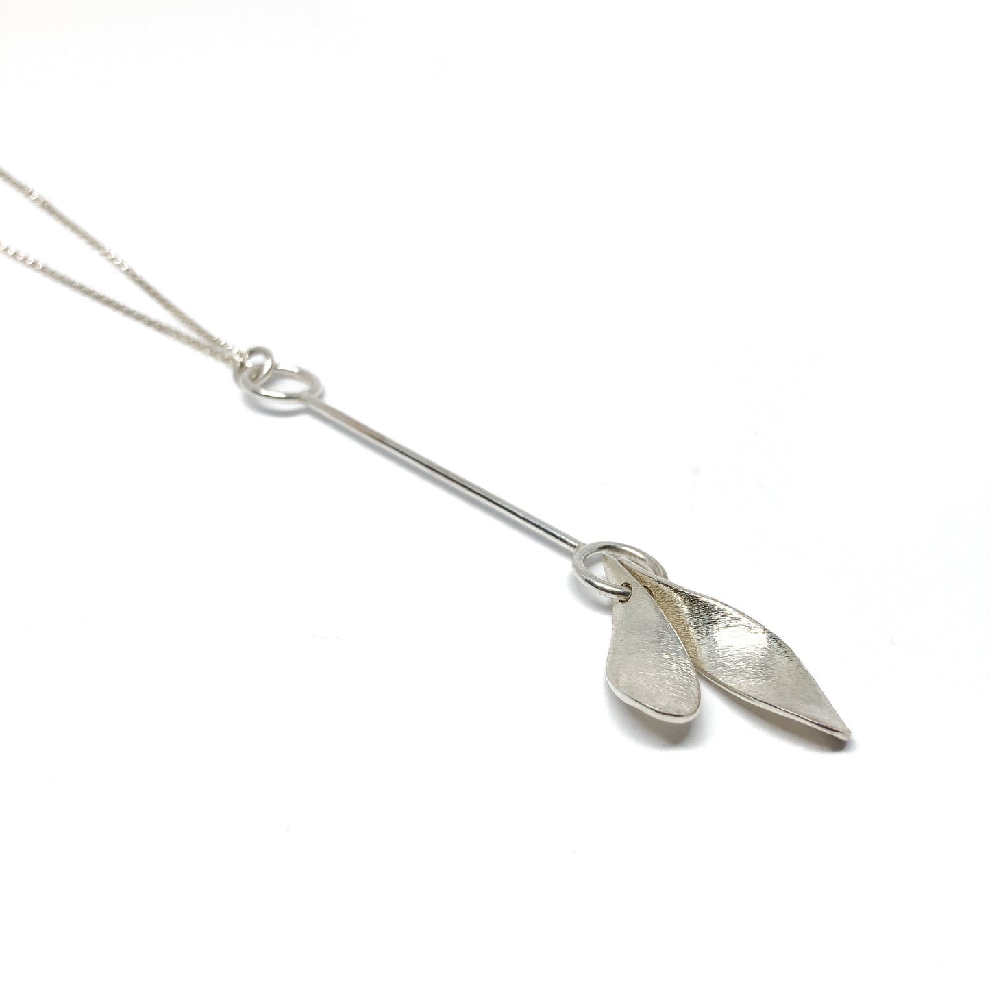 Silver necklace with two leaf-shaped pendants, close-up view.