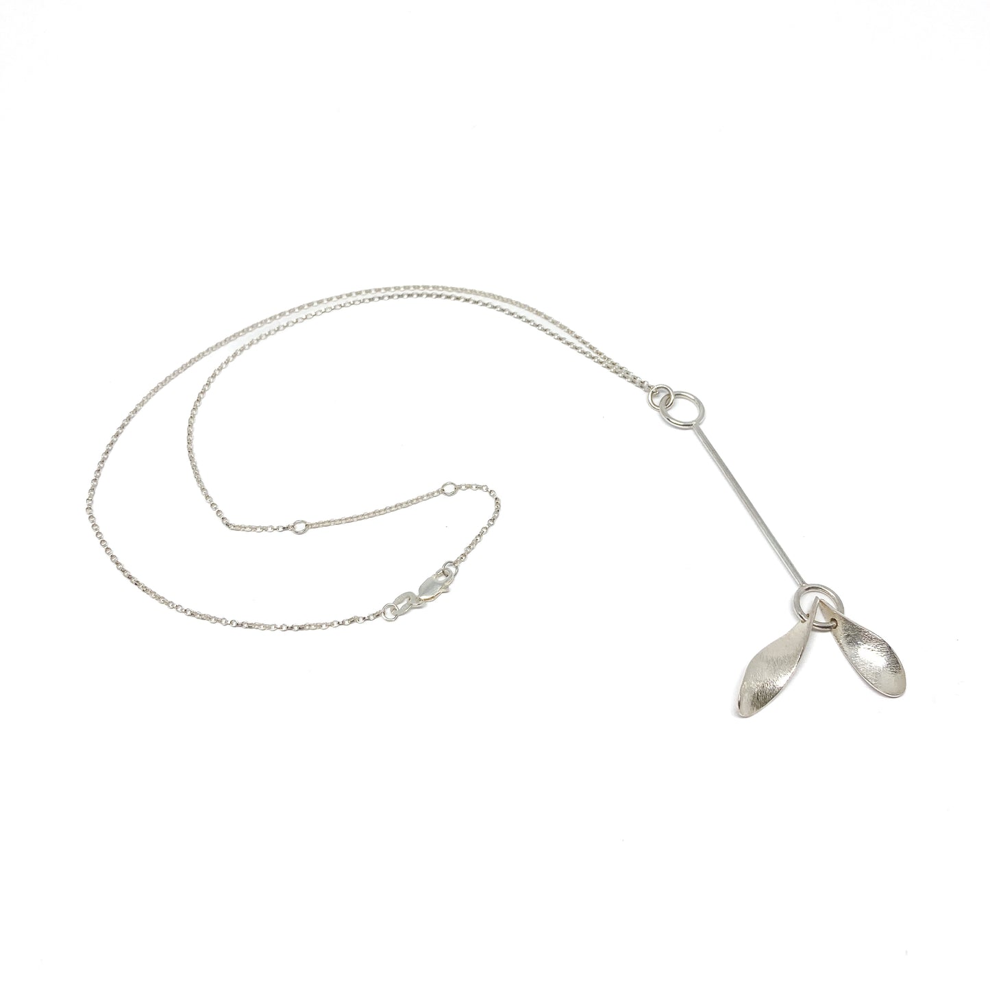 Silver necklace with leaf pendants, chain detail visible, angled.