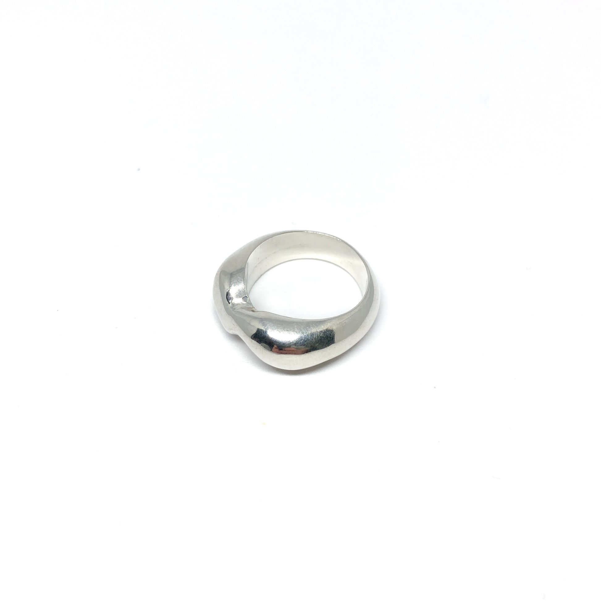 Modern silver ring with a curved, sculptural design.