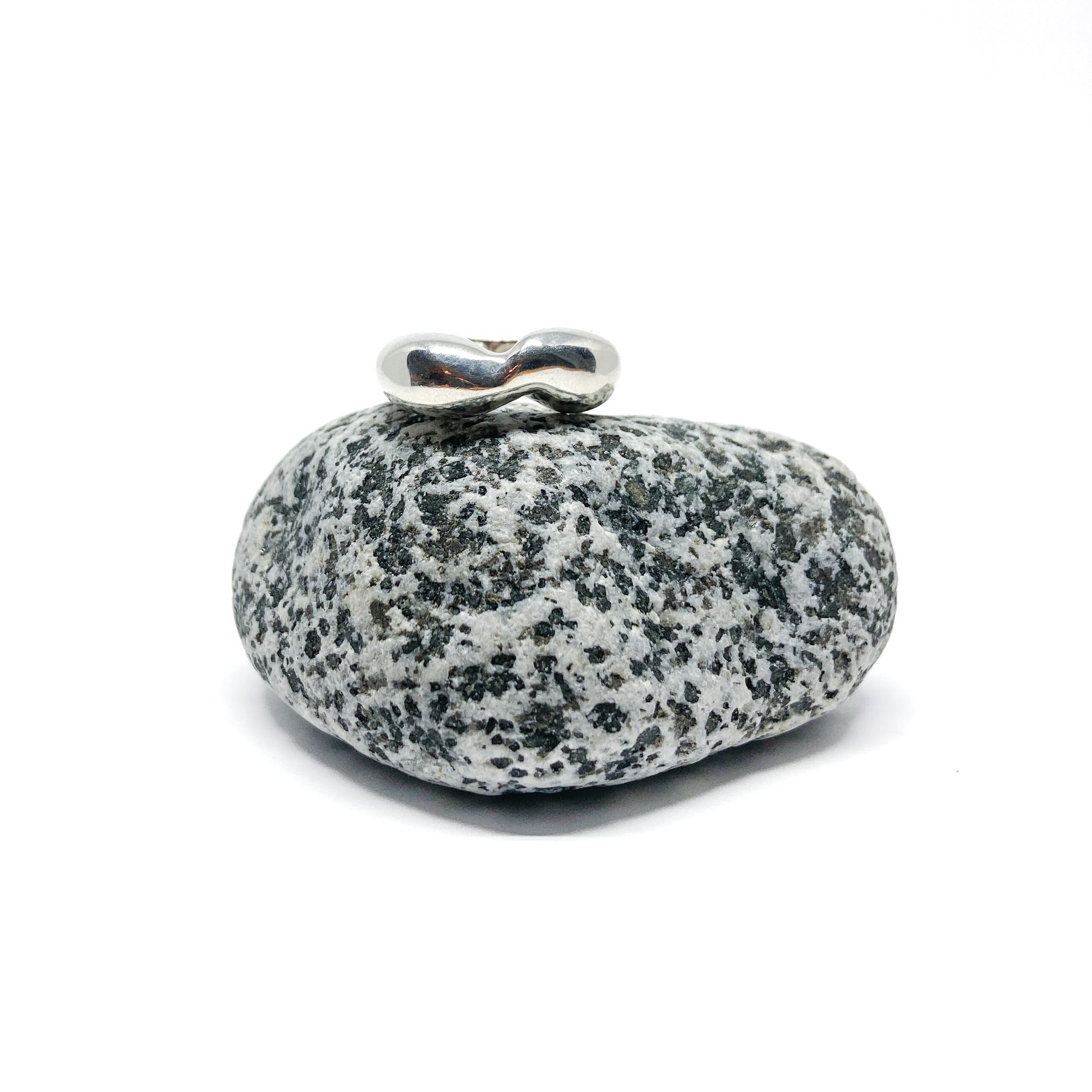 Silver ring on speckled gray stone.
