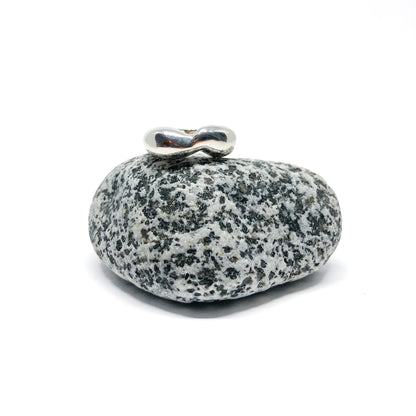Silver ring on speckled gray stone.
