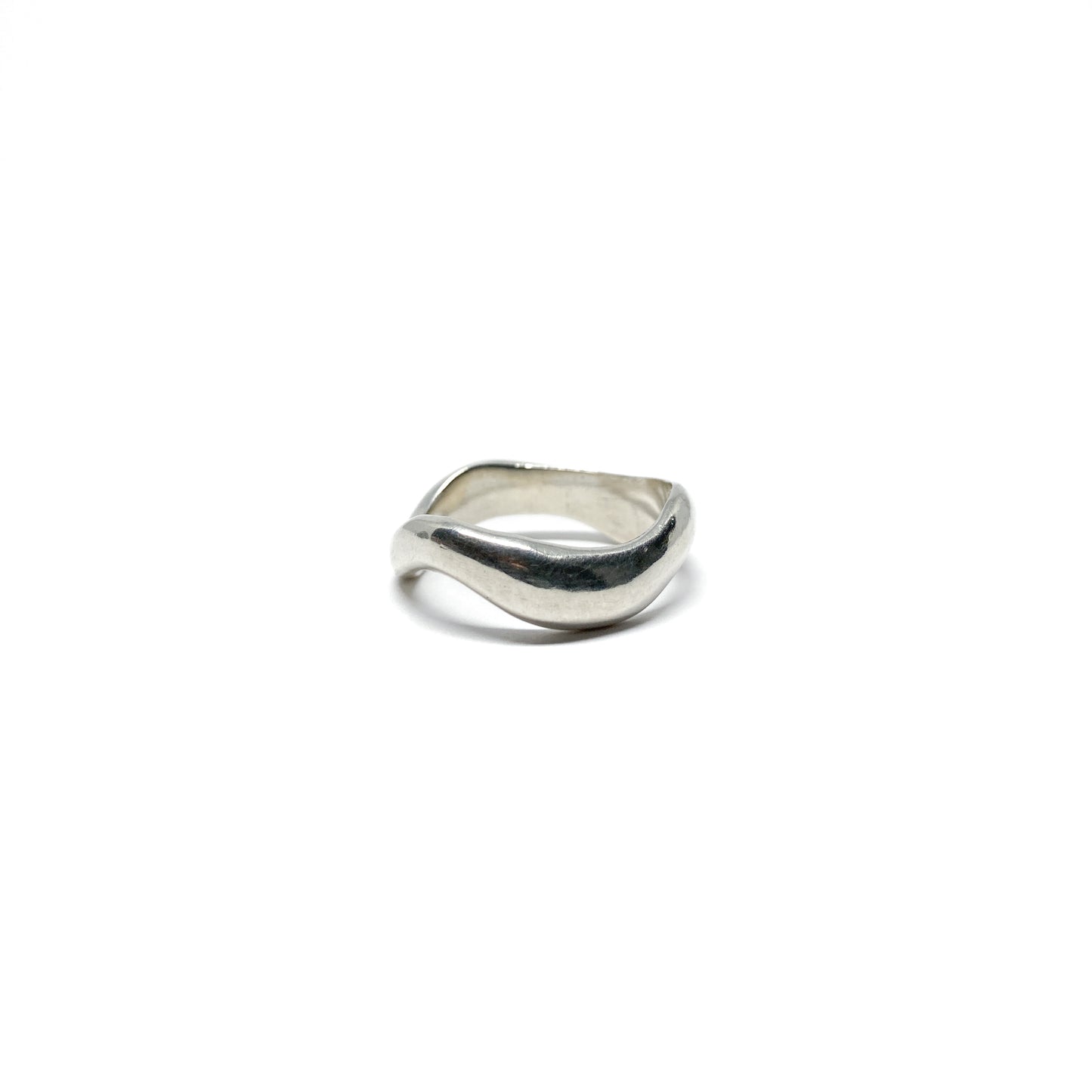 Modern silver ring with a fluid, sculptural design.