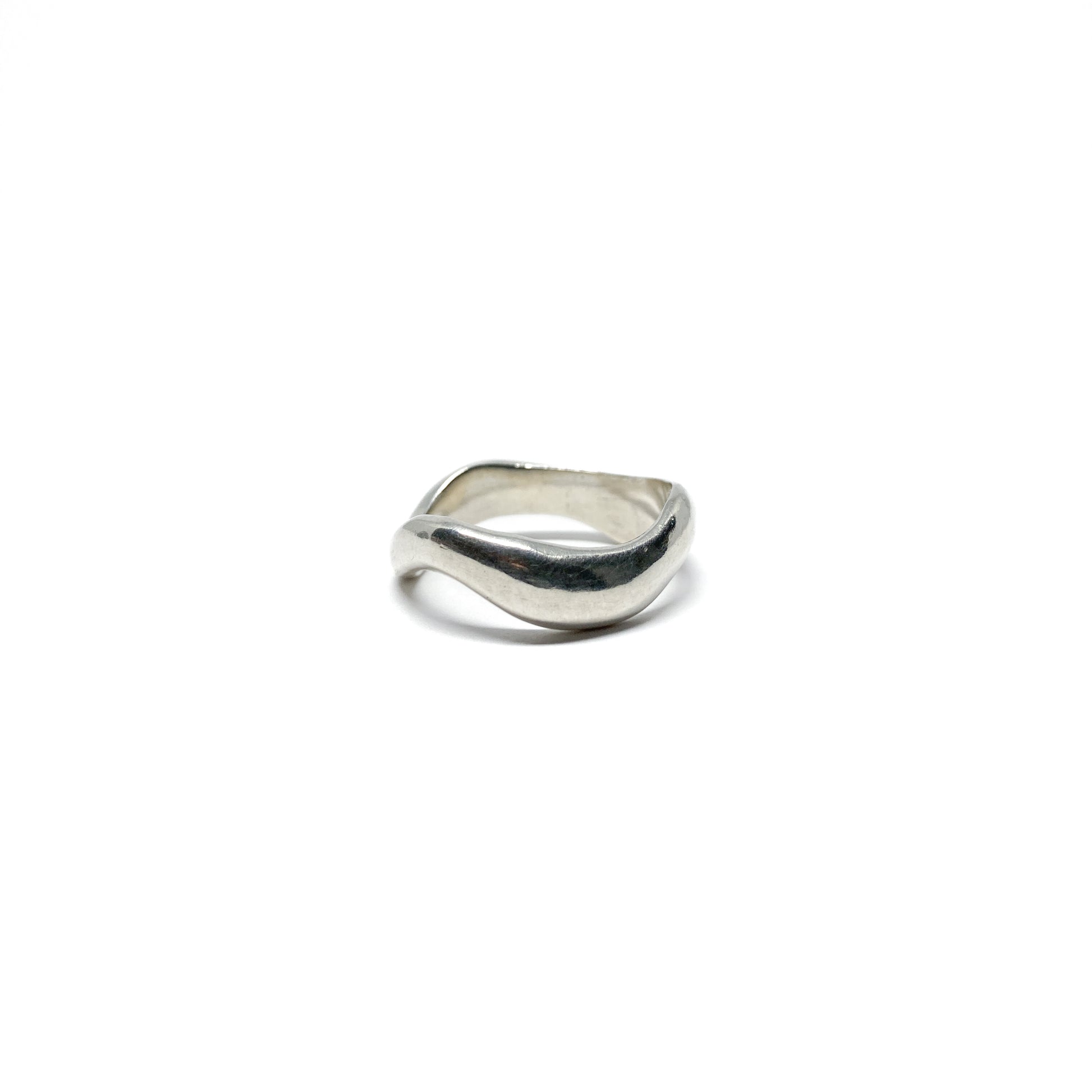 Modern silver ring with a fluid, sculptural design.