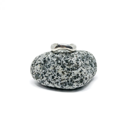 Silver ring on a textured gray stone, close-up.