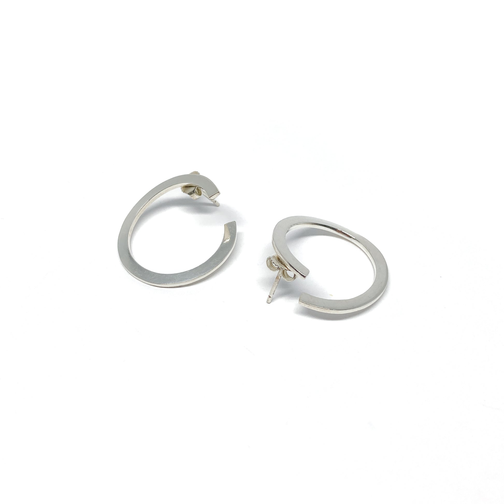 Modern silver hoop earrings, open design.