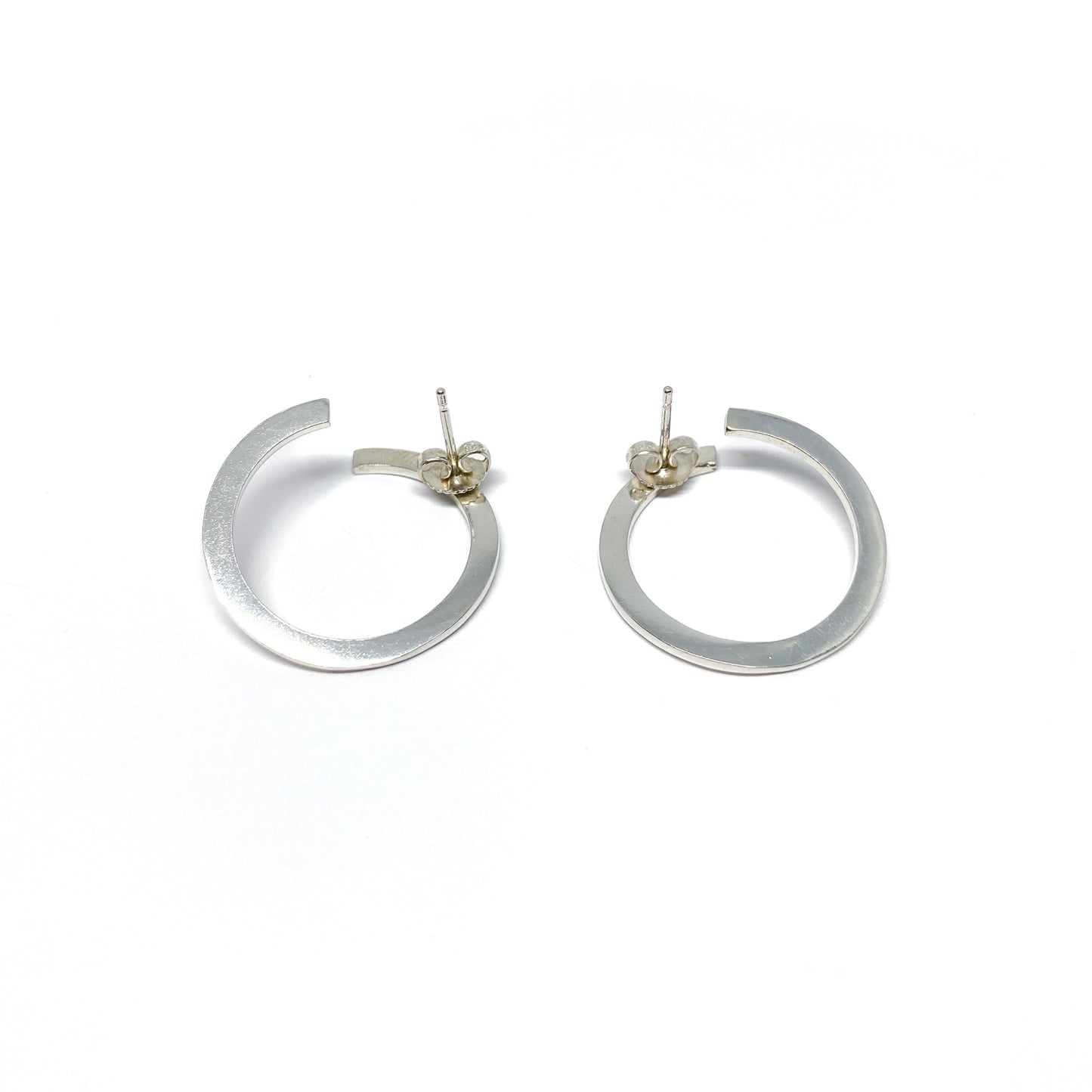Modern silver hoop earrings, open design.