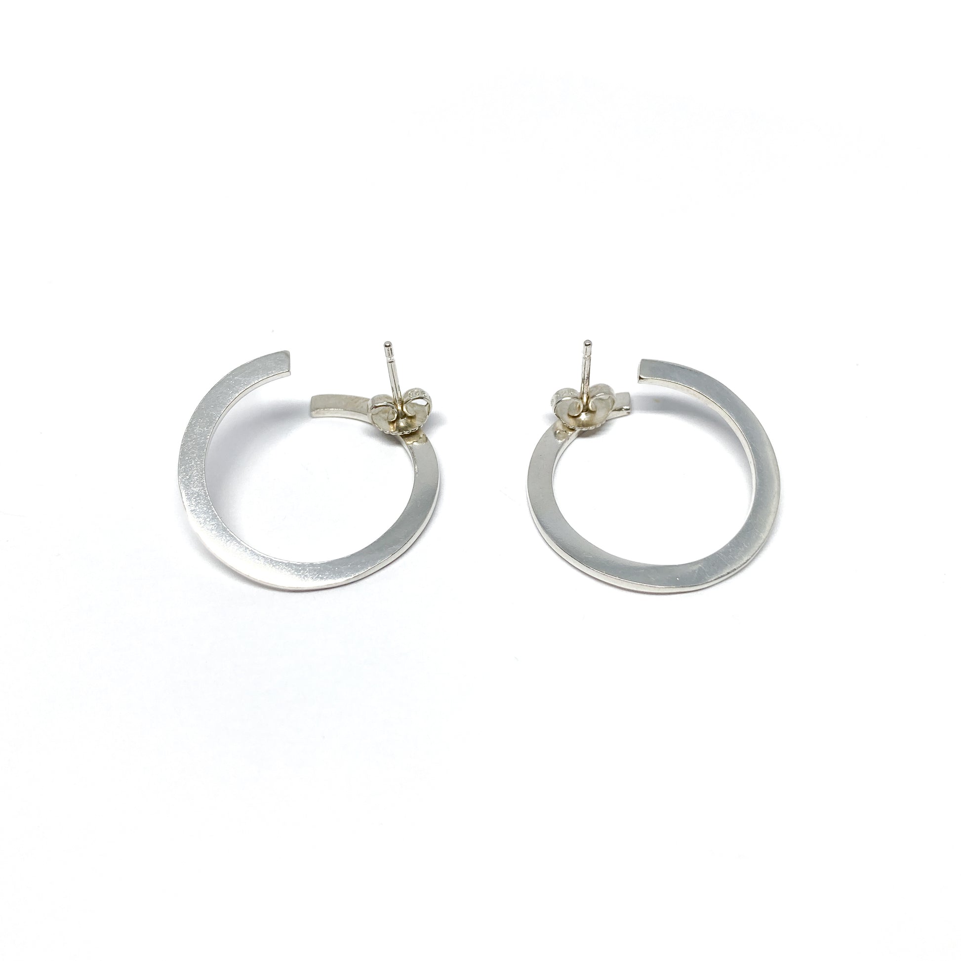 Modern silver hoop earrings, open design.