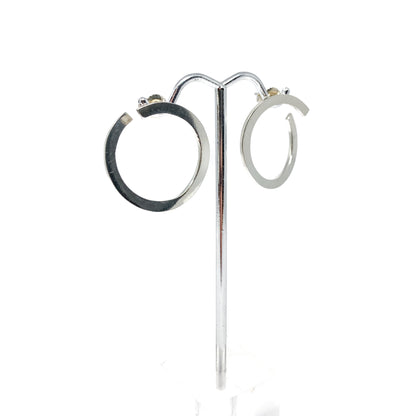 Silver open hoop earrings on a stand, front view.