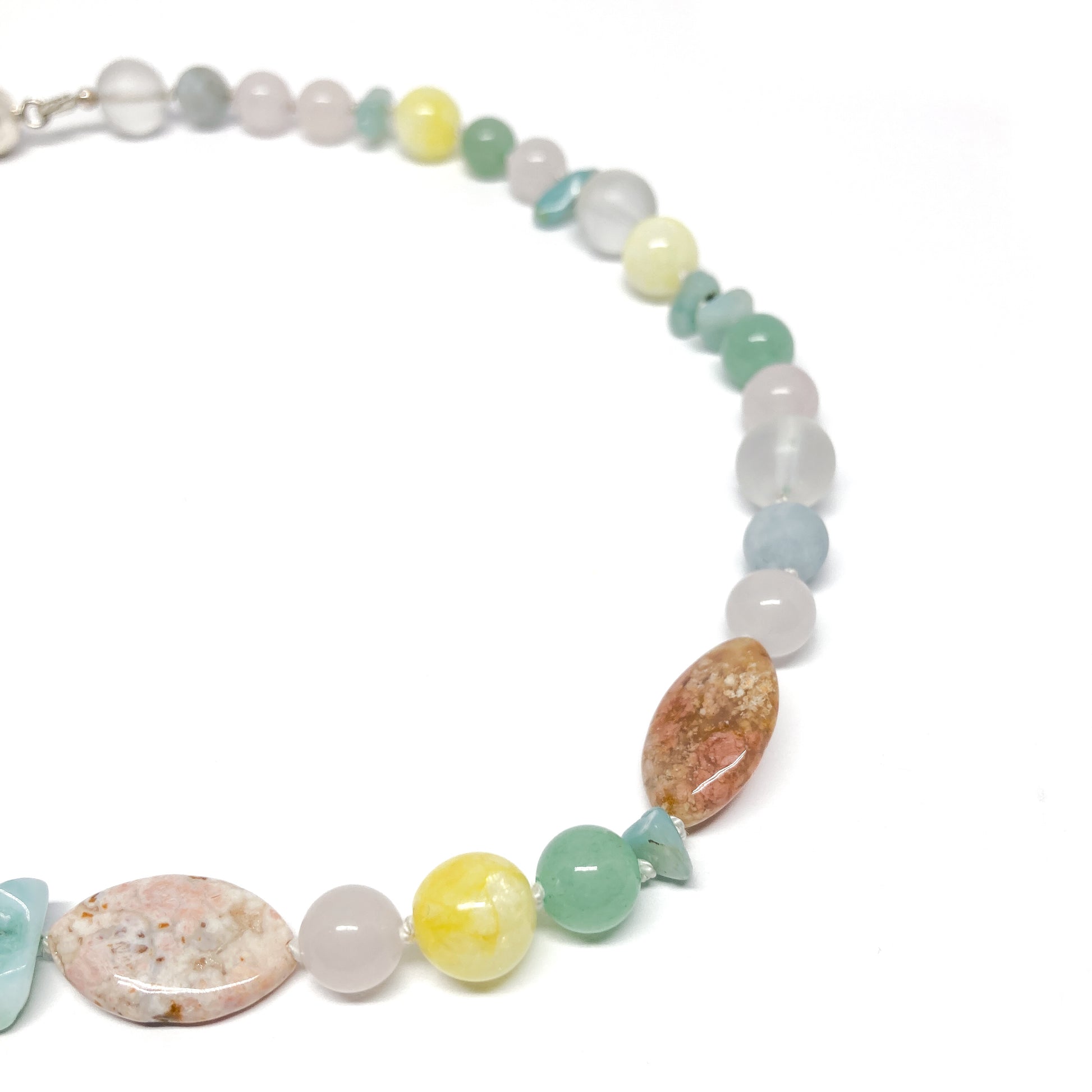 Close up pastel beaded necklace with various stones.