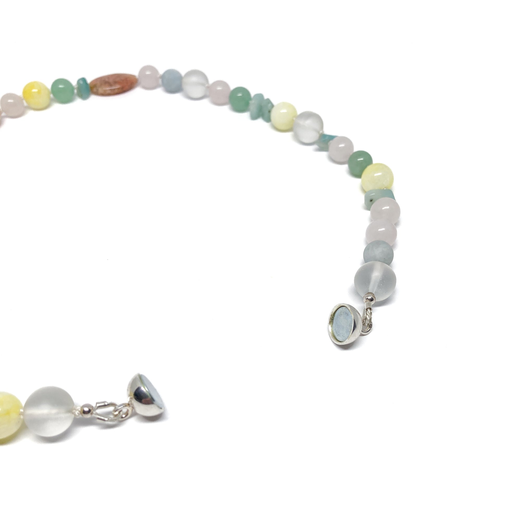 Light stone necklace, silver clasp detail visible.