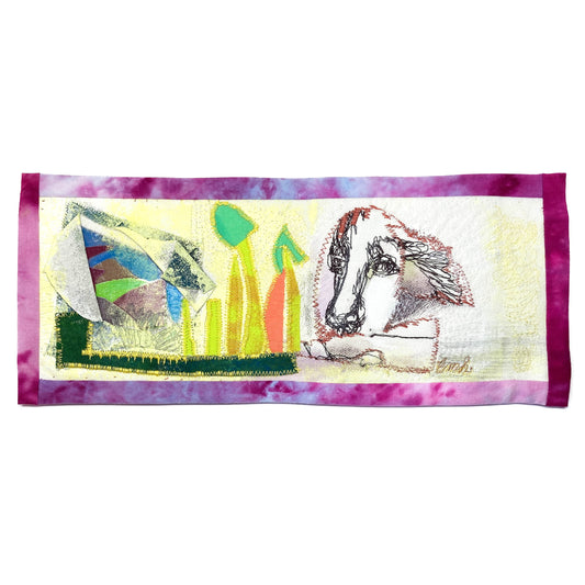 Textile art panel featuring abstract shapes, stitched green and orange forms, and a stylized line drawing of a dog's head.