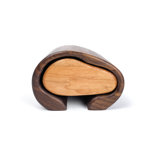Handcrafted wooden jewelry box with a smooth, light-toned sliding drawer nestled within a darker, curved outer shell.