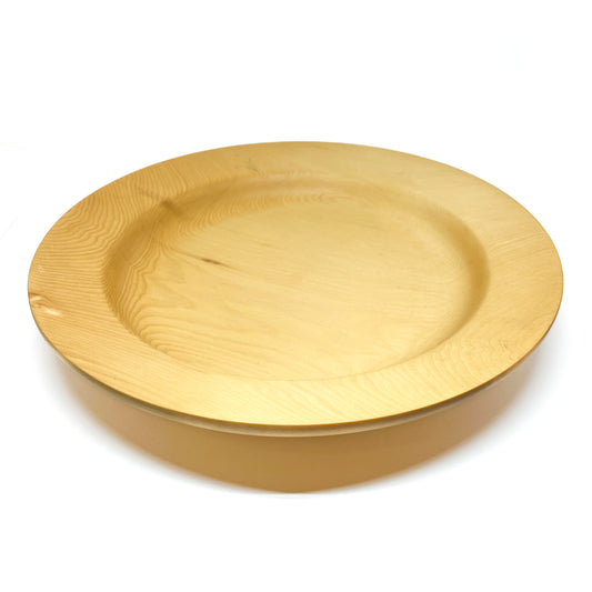 A top-down view of a rimmed yellow cedar plate with a wide, shallow bowl.