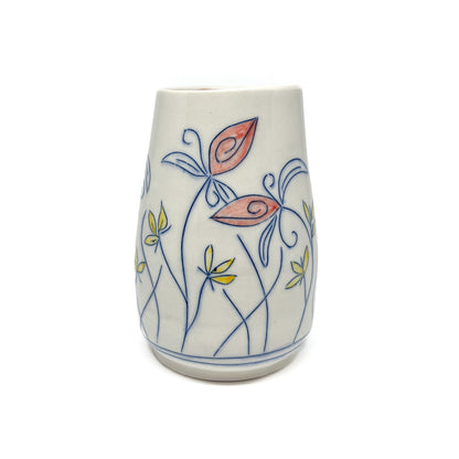 A white ceramic vase with a flared shape is decorated with blue outlined flowers and stems featuring reddish-orange and yellow petal details. The inner glaze is light brown.