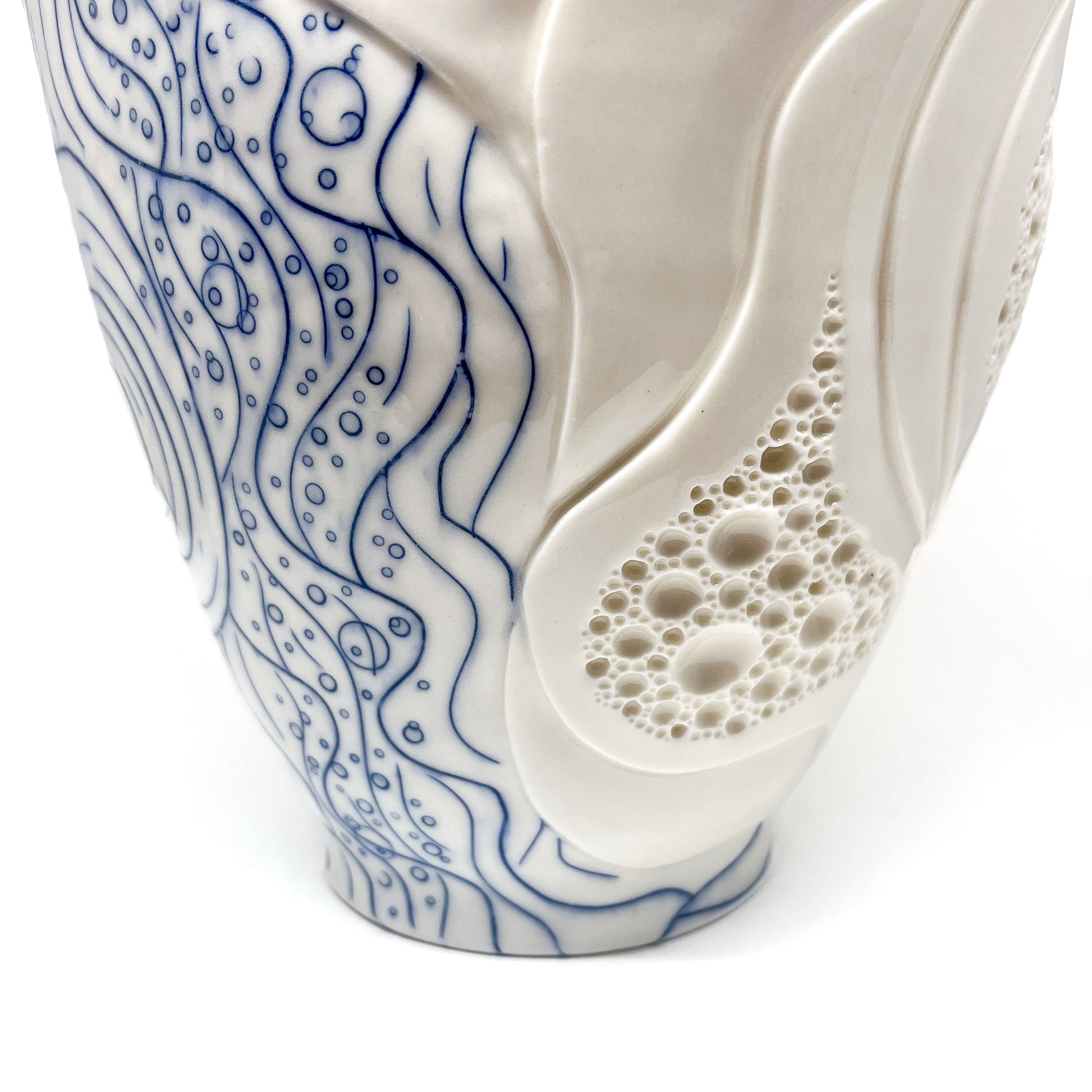 Detailed view of a ceramic bowl with blue abstract lines and textured bubble and swirl designs.