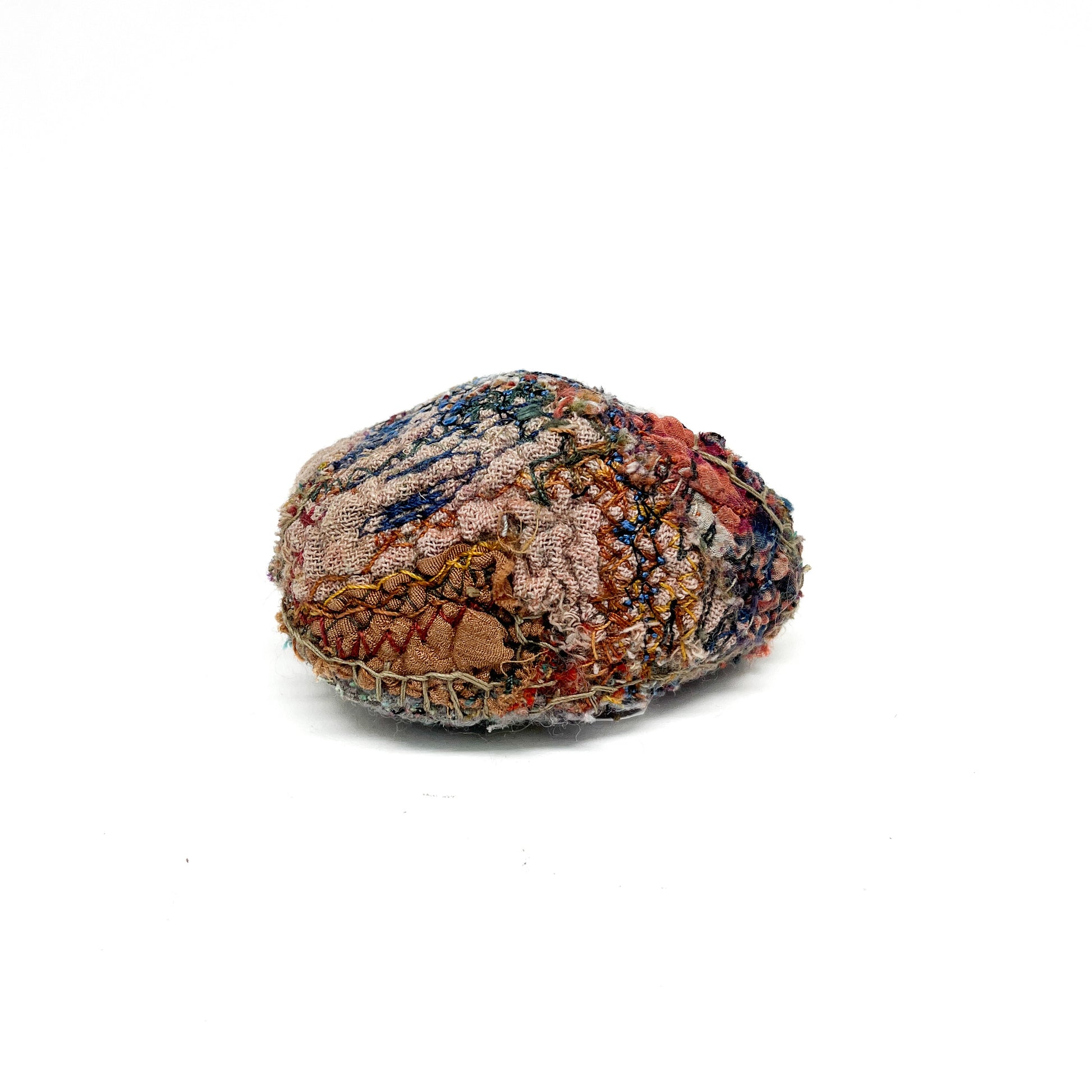 Embroidered Rock by Jane Kenyon: Round textured textile art resembling a rock, with intricate stitching in earth tones and blues.