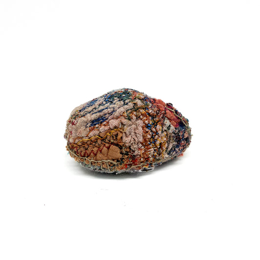 Embroidered Rock by Jane Kenyon: Round textured textile art resembling a rock, with intricate stitching in earth tones and blues.