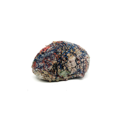 Embroidered Rock by Jane Kenyon: Round textured textile art resembling a rock, with dense stitching in blue, red, white, and tan threads.