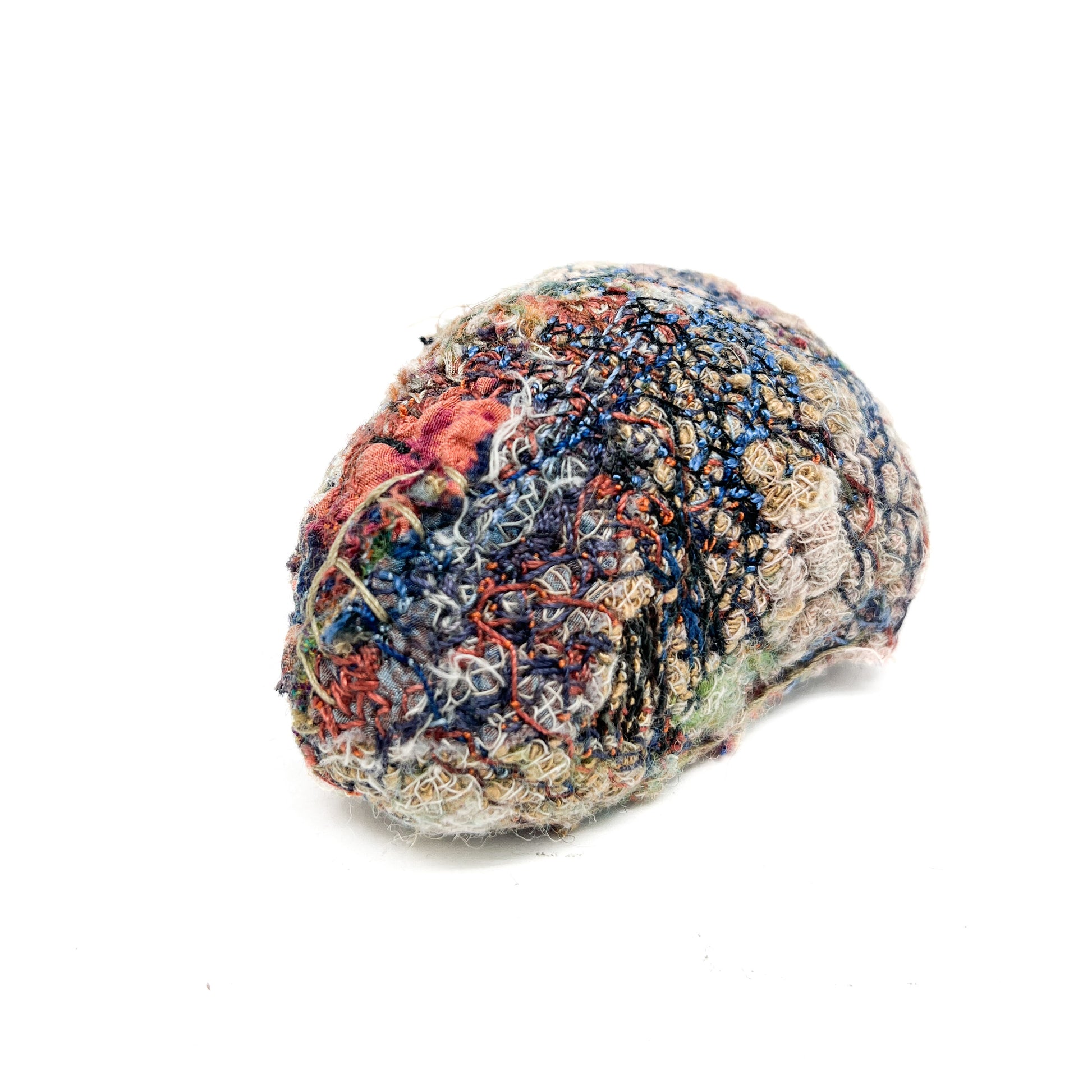 Embroidered Rock by Jane Kenyon: Round textured textile art resembling a rock, with layers of colorful and textured thread stitching.