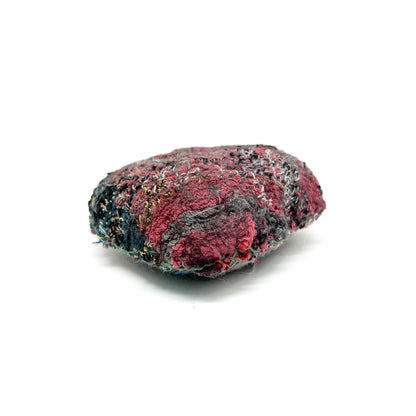 Embroidered Rock: Oval textured textile art resembling a rock, with deep red, gray, and black thread stitching.