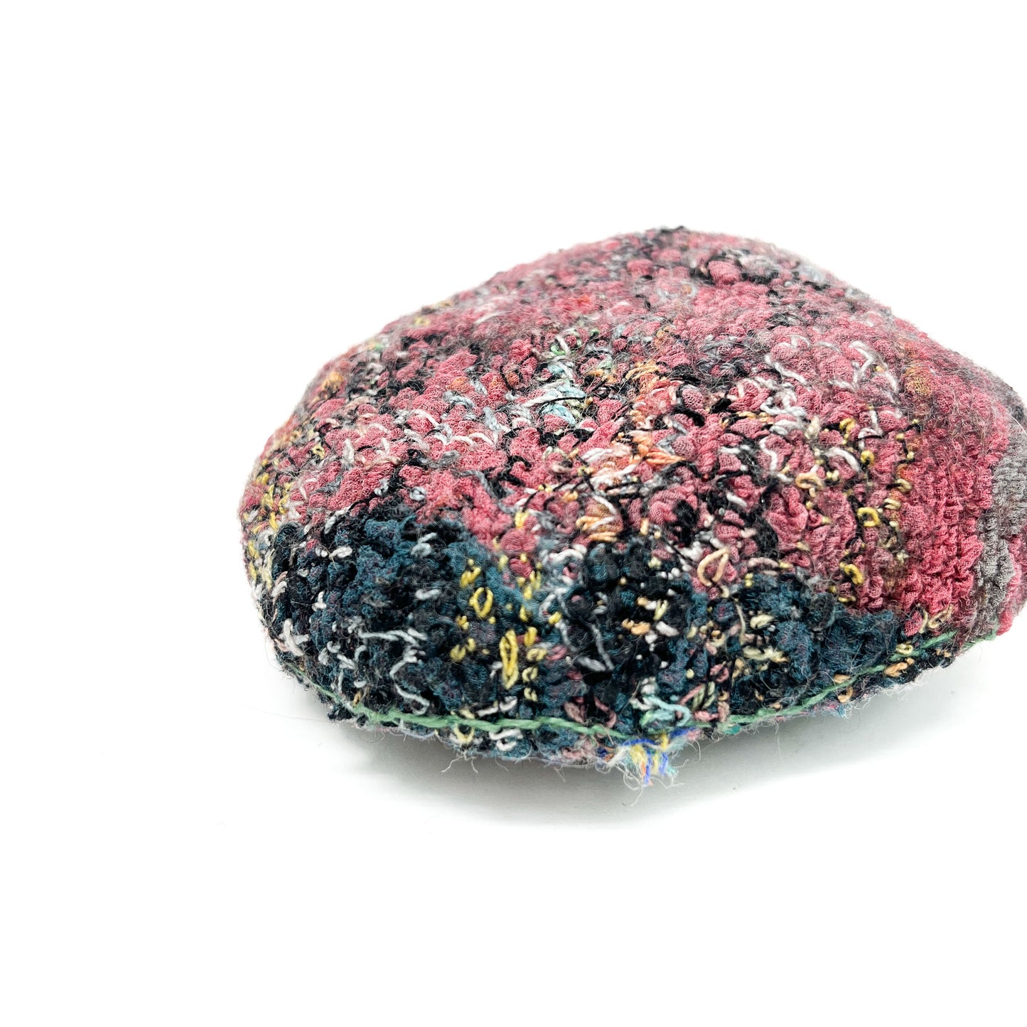 Embroidered Rock: Round textured textile art resembling a rock, with layered stitching in pink, black, blue, and yellow threads.