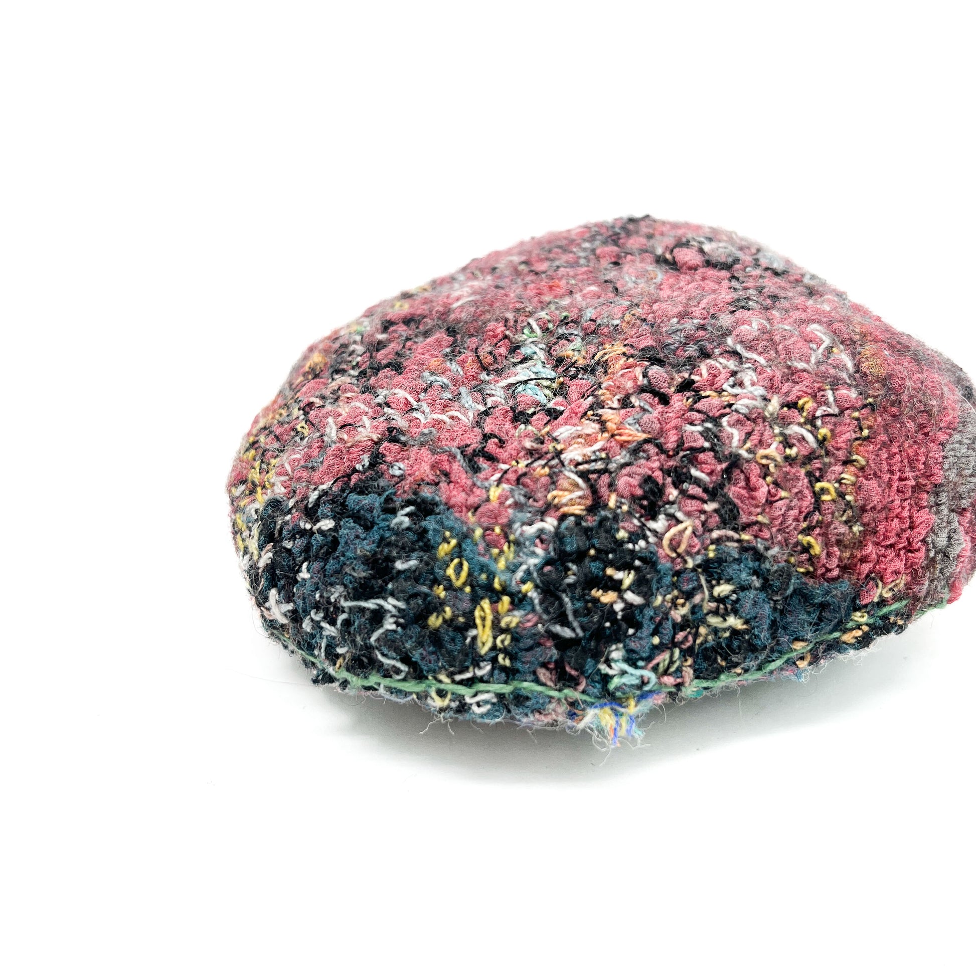 Embroidered Rock: Round textured textile art resembling a rock, with layered stitching in pink, black, blue, and yellow threads.
