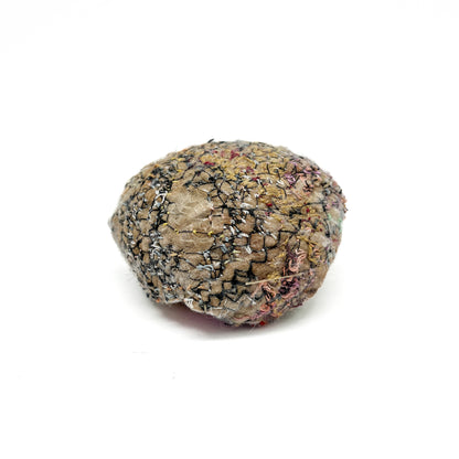 Embroidered Rock: Round textured textile art resembling a rock, with detailed stitching in earth tones and black threads.