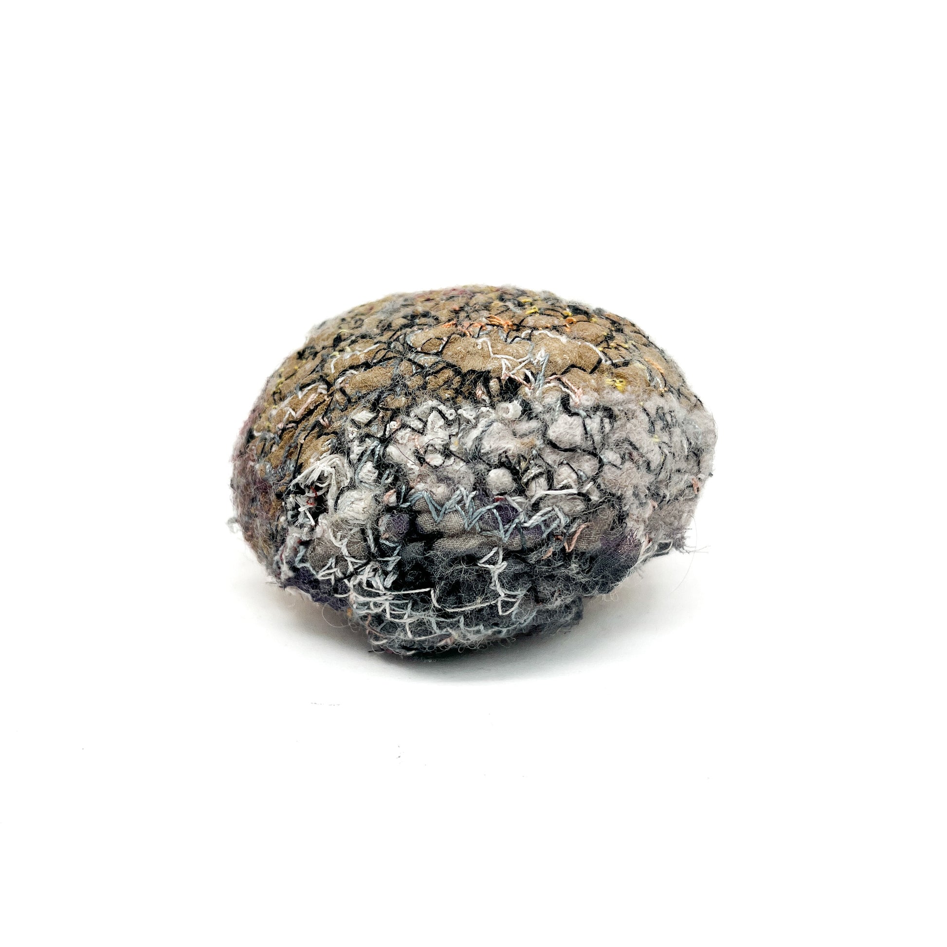 Embroidered Rock: Round textured textile art resembling a rock, with intricate stitching in gray, white, and black threads.