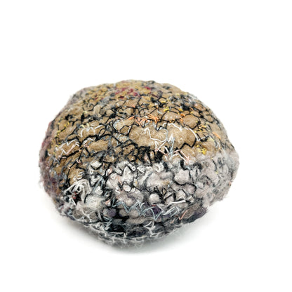 Embroidered Rock: Round textured textile art resembling a rock, with layers of gray, black, and tan thread stitching.